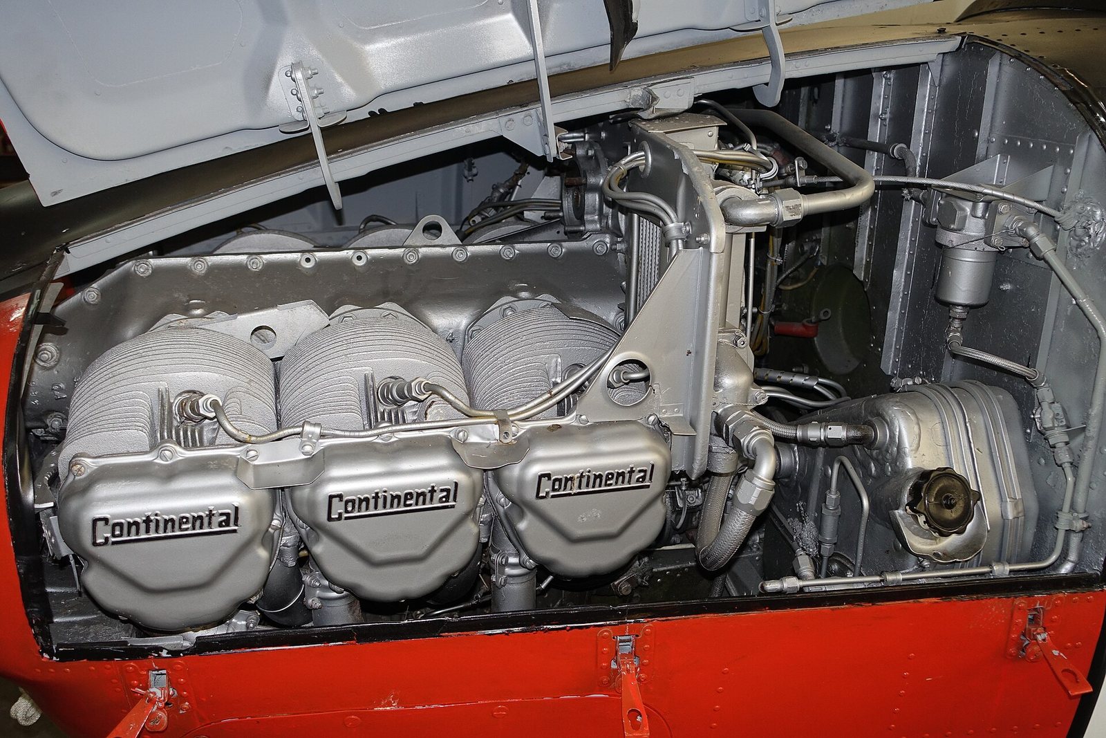A six-cylinder piston aircraft engine installed in an airplane, with the cowling open