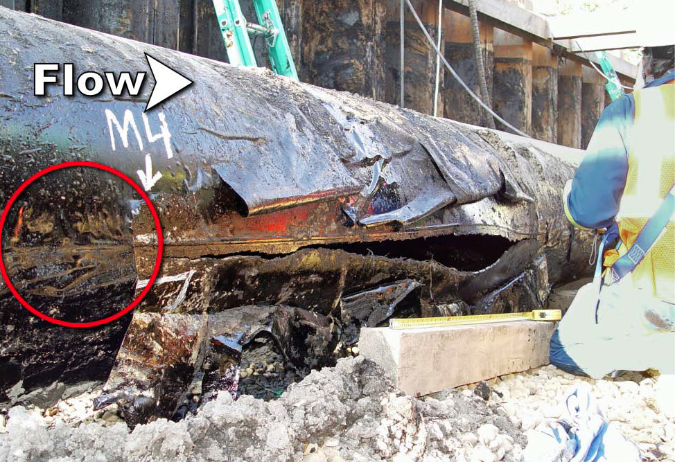 A ruptured segment of buried gas pipeline exposed in its trench during a failure investigation