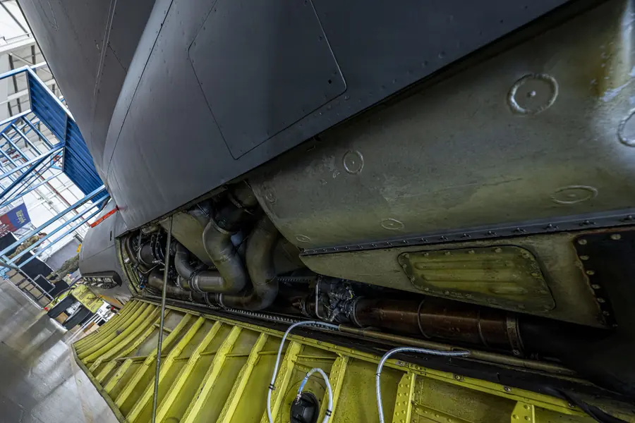 The underside of an aircraft with access panels removed for inspection