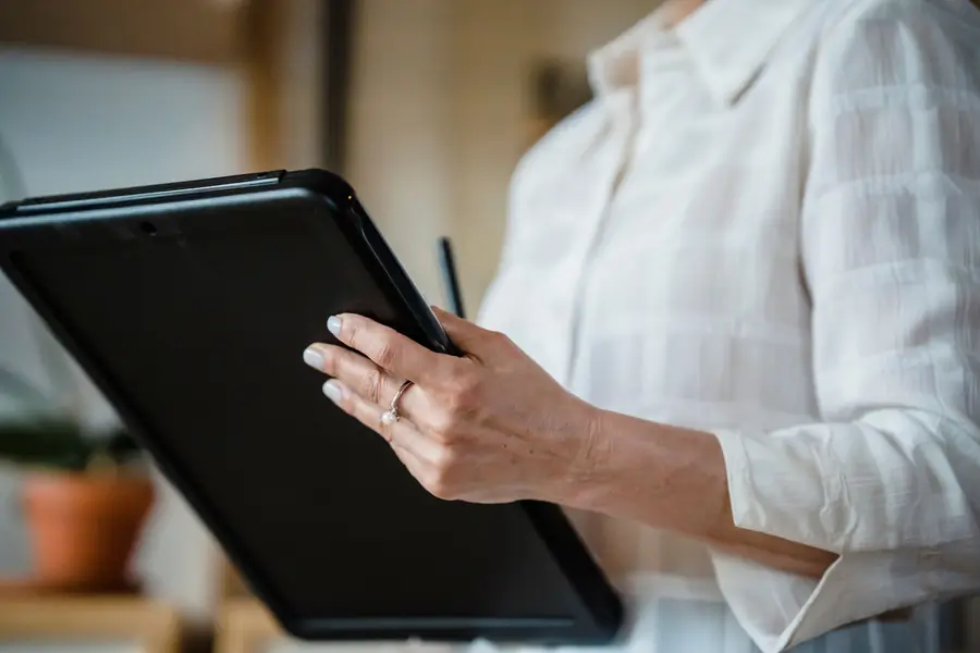 Hands holding a tablet showing a report