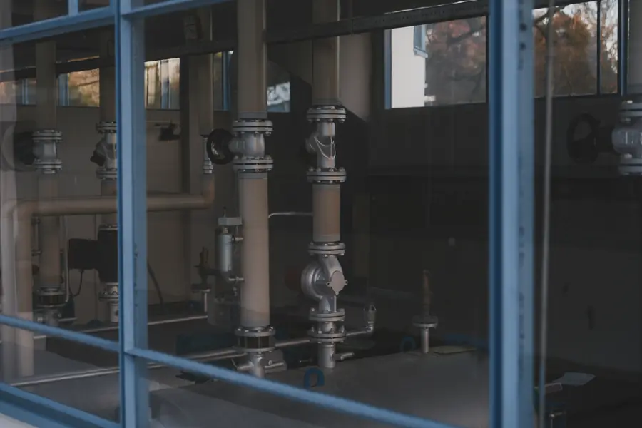 Industrial pipes, flanges and machinery inside a facility