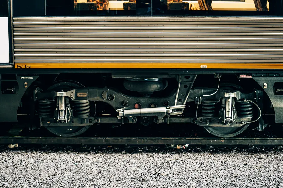Close-up of a train's wheels and running gear on the track