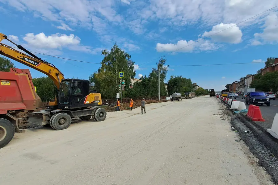 An excavator and a dump truck at a road construction site